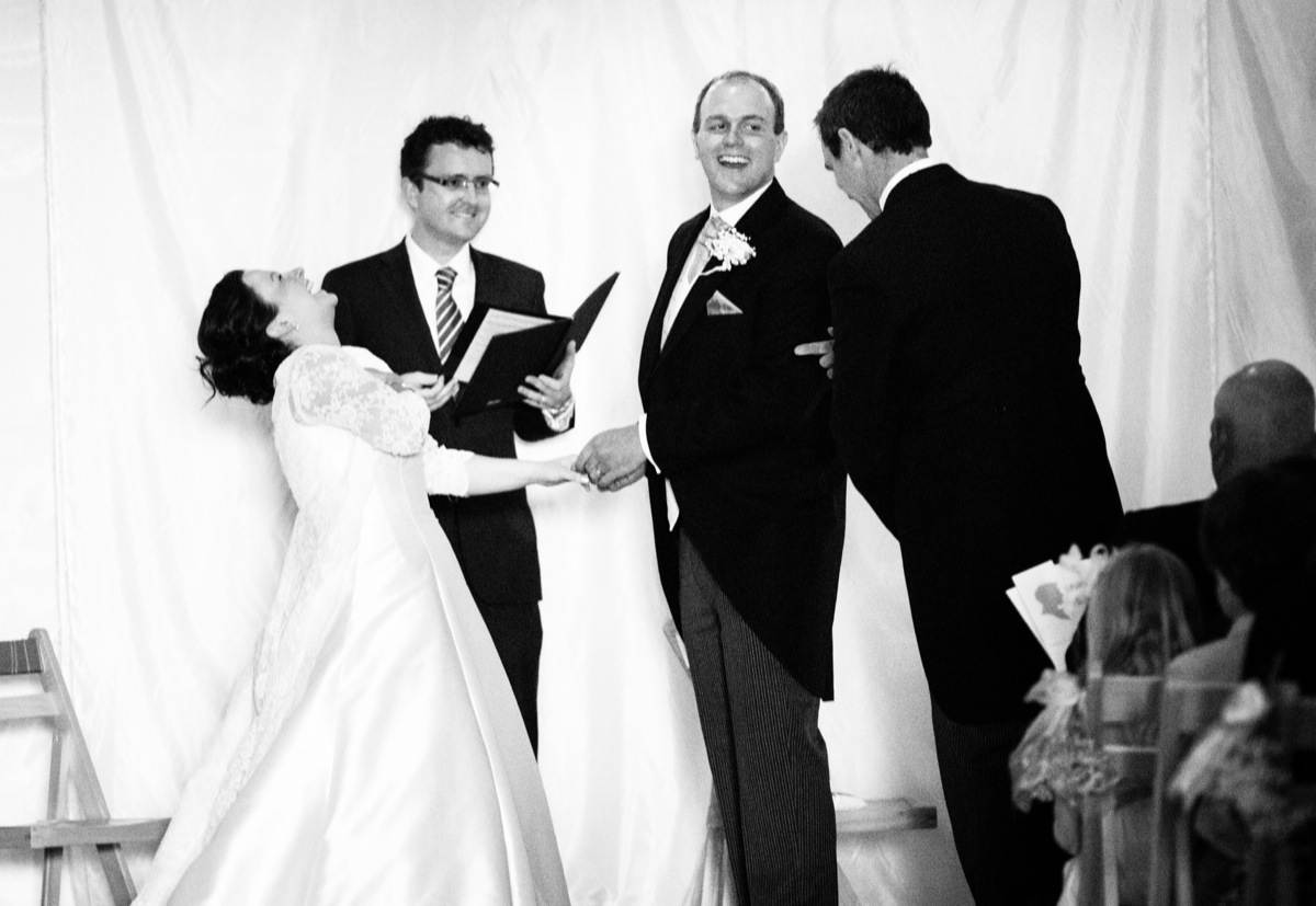 Bride, groom, celebrant and best man laughing during ceremony