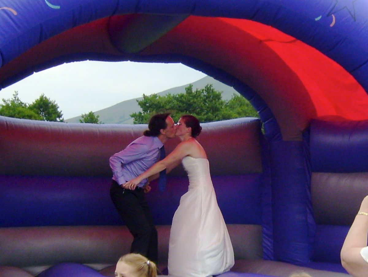 Bride and groom kiss on a bouncy castle
