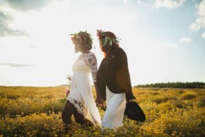 Image of two brides walking in a field