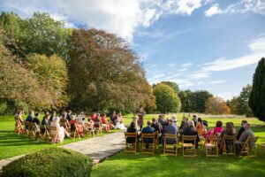 An outdoor wedding at Crayke, North Yorkshire, led by celebrant Rachael Bowers. Rows of guests sit outside at an autumn wedding.